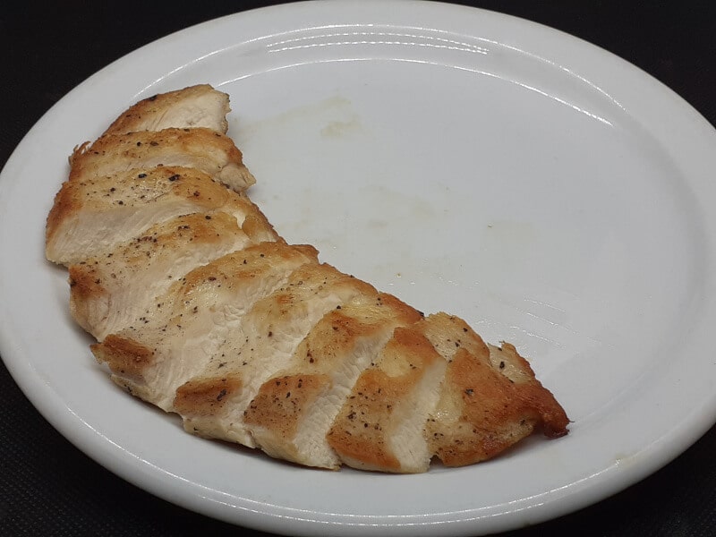 Seared Chicken Breast Sliced and around the Plate