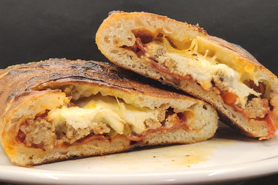 JAHZKITCHEN Calzone sliced in half Pepperoni, Sausage and Bacon